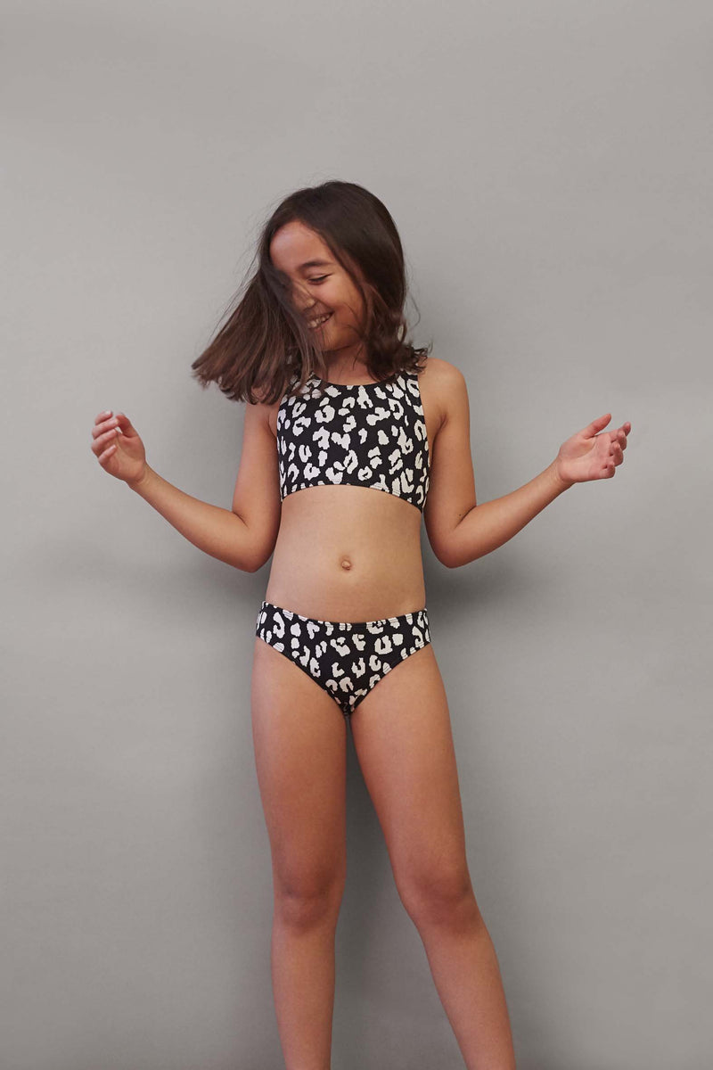 This modern sporty style bikini top has a cut-away neckline with crossover adjustable tie at the back. Featuring good coverage with a playful twist - the bikini bottoms are inspired by a 60s silhouette, with a low cut waist and low cut leg with full bottom coverage. 